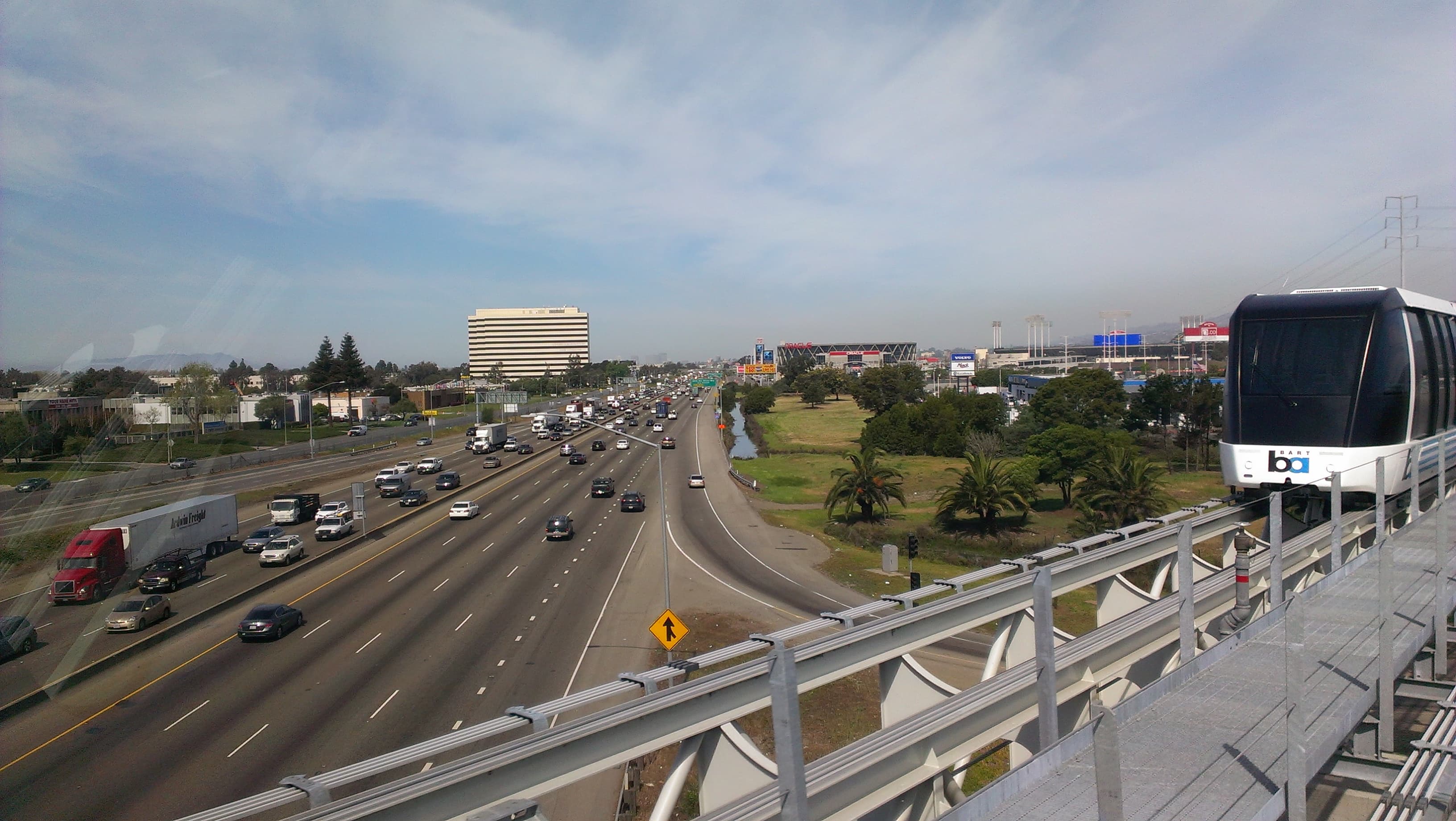 Bay Area BART train traveling beside a regional freeway